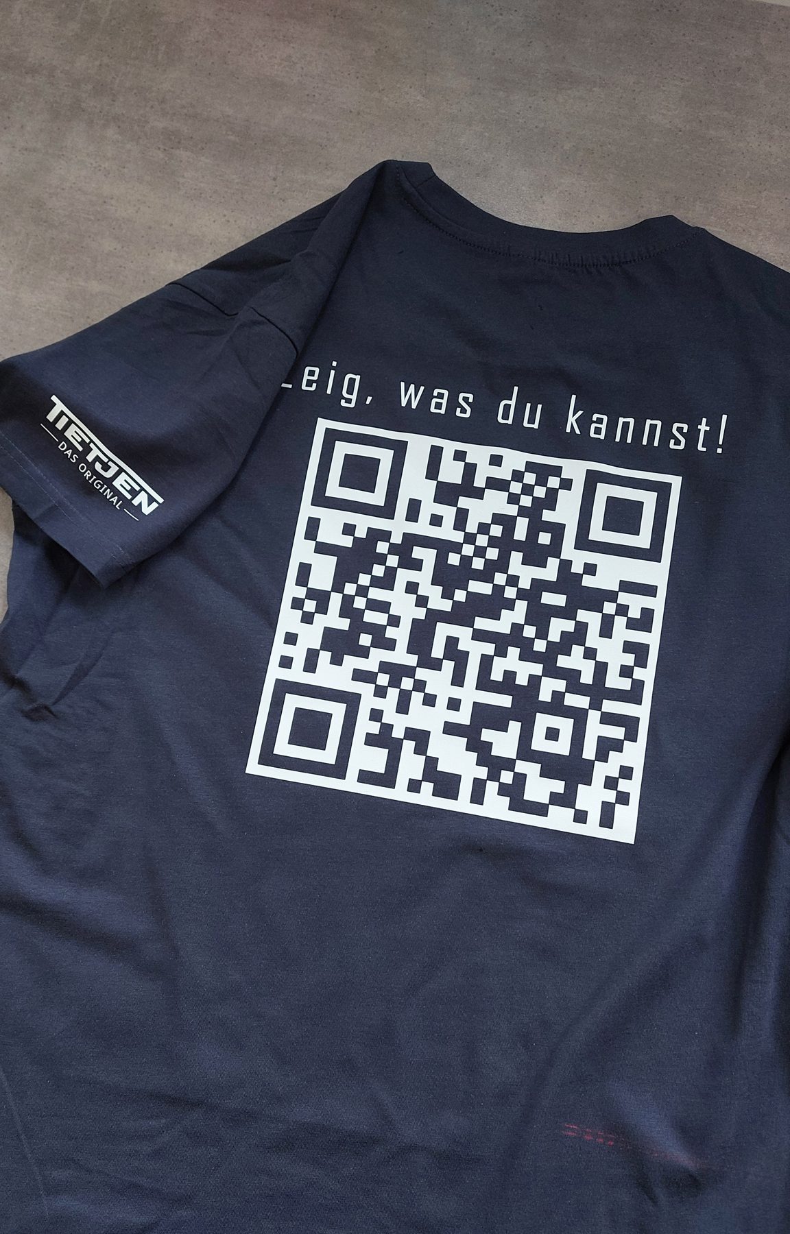 Dunkelblaues Shirt mit großem QR-Code und Spruch auf dem Rücken