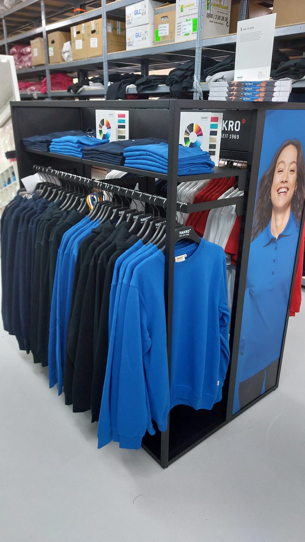 HAKRO-Aufsteller mit Sweatshirts und Poloshirts im Showroom von DruckStudio Norderstedt