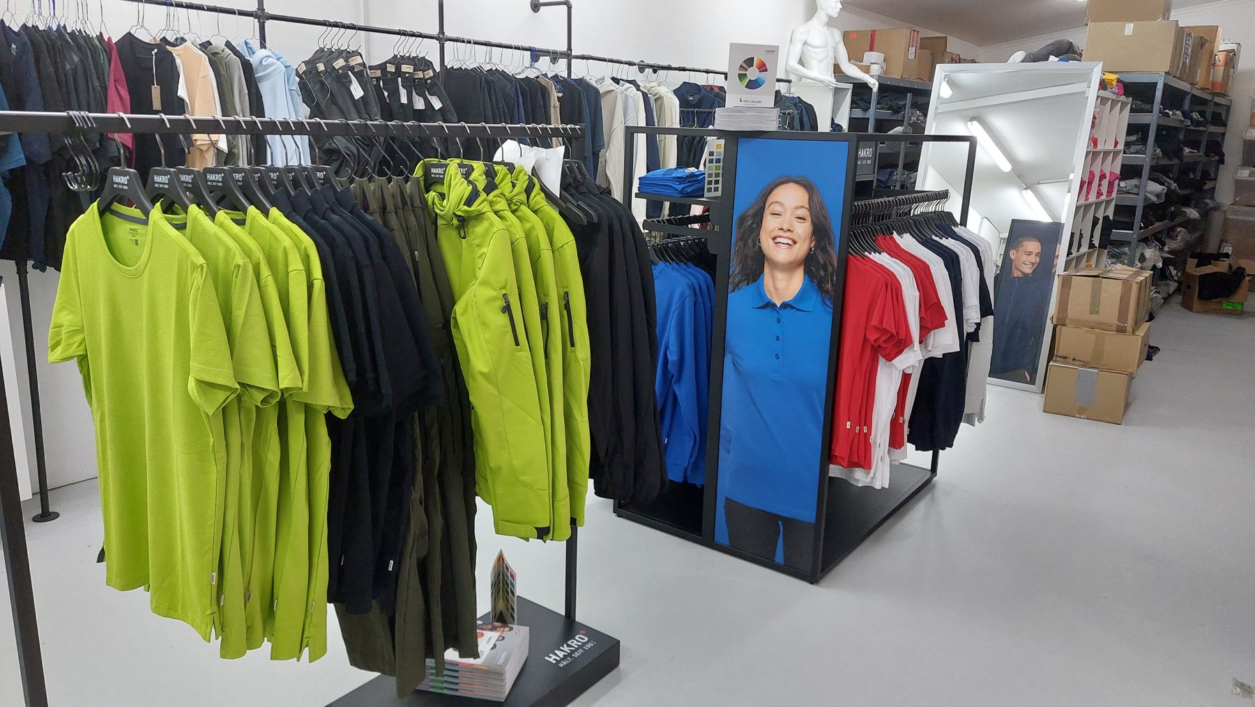 Kleiderstangen mit Polos und Softshelljacken im Showroom