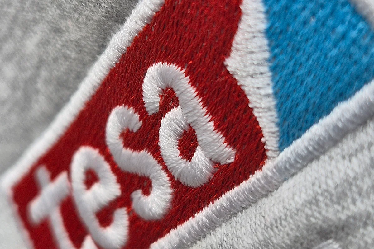 Gesticktes Logo auf meliertem Sweatshirt, Nahaufnahme der Stickerei